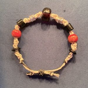 This bracelet is made with hemp. With glass, wood and metal beads